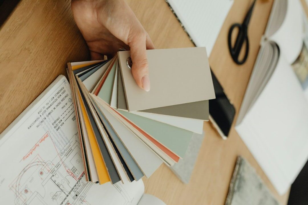 Designer holding colour swatches over floor plans, interior designer cost in Toronto